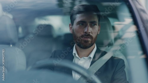 Handsome adult caucasian businessman in formal suit driving his car commuting to work. Business person. Successful people. Luxury lifestyle. Positive mood.