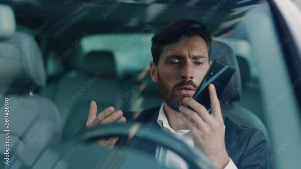 Stressful adult businessman waiting in traffic jam calling transport services receiving no answer getting angry. Angry emotions. Frustration, tiredness. Commuting.