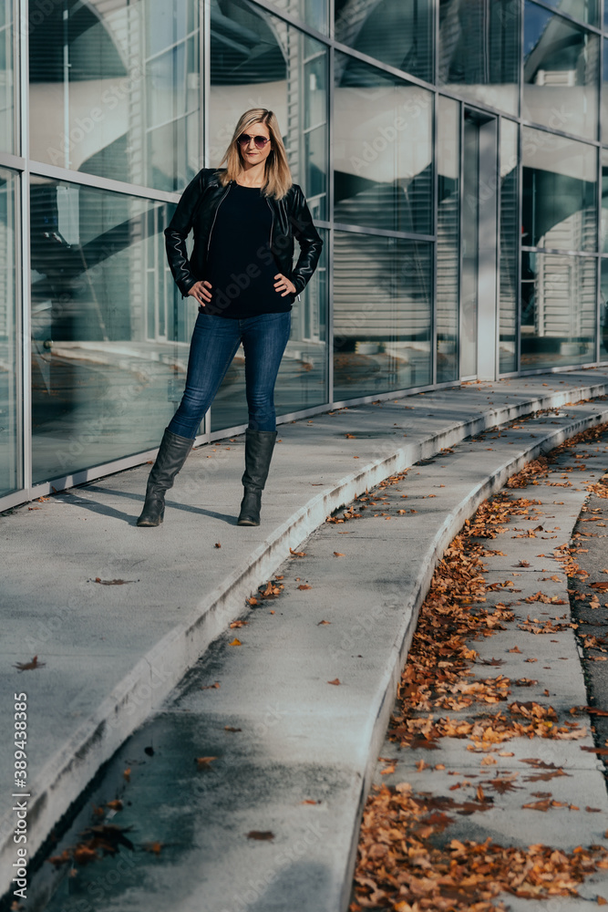 Portrait of attractive young caucasian blonde woman standing in front of business building Portrait of attractive young caucasian blonde woman standing in front of business building