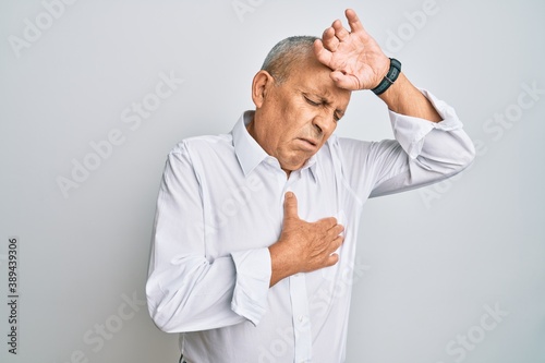 Handsome senior man wearing casual white shirt touching forehead for illness and fever, flu and cold, virus sick