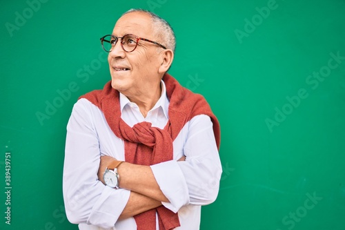 Senior man smiling happy wearing glasses walking at the city. © Krakenimages.com
