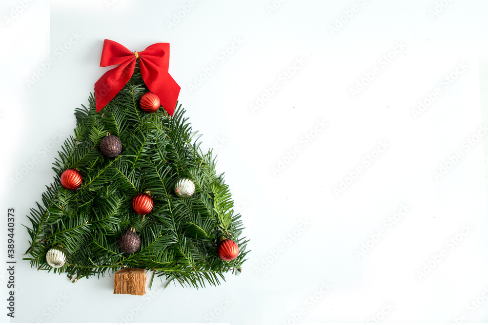 Creative Handmade Christmas tree on a white background, with a red bow and decorative balls. Flat lay.