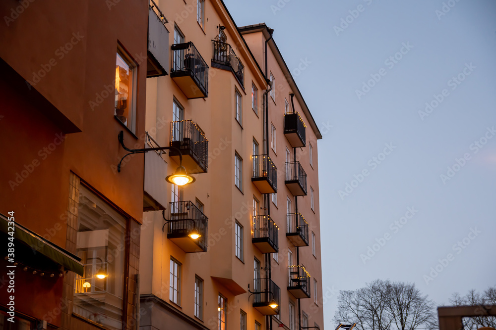 Building in Stockholm decorated with yellow light garlands. Windows and balconies of the house. Winter, christmas decoration