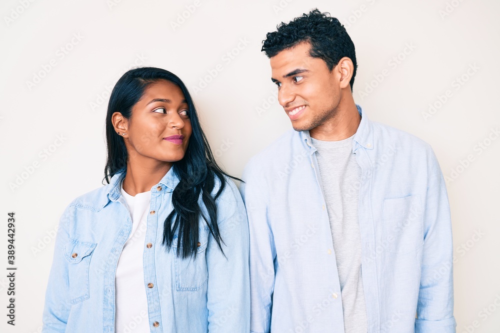 Beautiful latin young couple wearing casual clothes smiling looking to the side and staring away thinking. Beautiful latin young couple wearing casual clothes smiling looking to the side and staring away thinking.