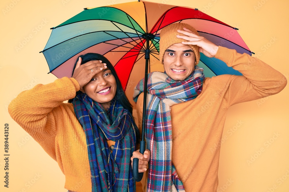 ryste Barry Alert Beautiful latin young couple under colorful umbrella stressed and  frustrated with hand on head, surprised and angry face Stock-foto | Adobe  Stock