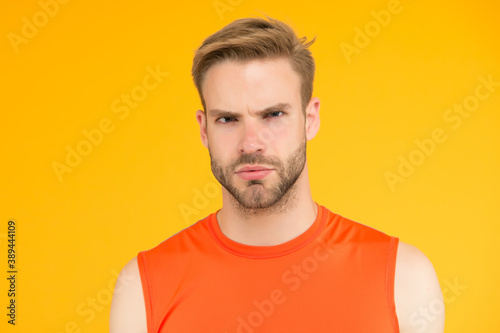 seriousness itself. unshaven guy with bristle. male sporty fashion. confident man in fitness vest. male hair beauty and care. serious man has trendy hairstyle. bearded young guy after barber shop