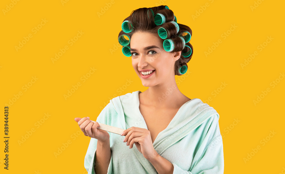 Cheerful Woman Using Nail Buffer Caring For Fingernails, Yellow Background Cheerful Woman Using Nail Buffer Caring For Fingernails, Yellow Background