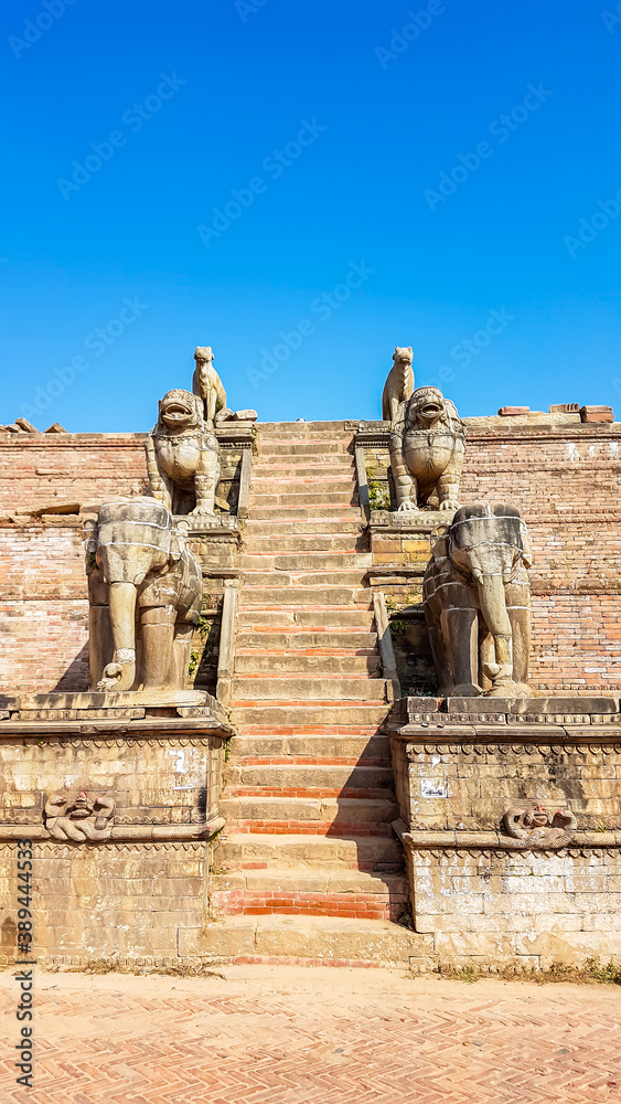 Staircase leading to one of the temples in Bhaktapur, Nepal. On both sides of the stairs there are Hindu Gods, guarding the entrance to the temple. The guardians are really big.