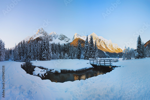 Obraz na płótnie Winter landscape in the Alps, Christmas card view. Lake Antholz (Anterselva) at sunset, Dolomites, Italy. The river against the background of snow-covered peaks. w salonie