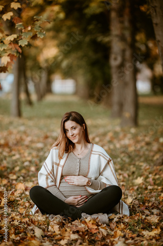 Cute pregnant woman wearing poncho in park