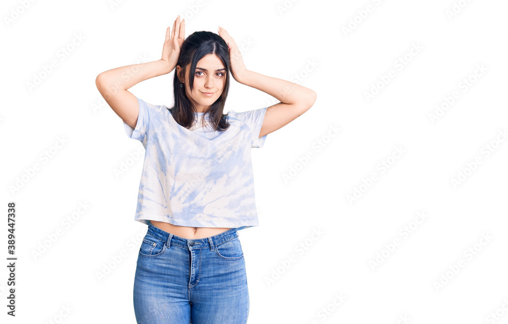 Young beautiful girl wearing casual t shirt doing bunny ears gesture with hands palms looking cynical and skeptical. easter rabbit concept.