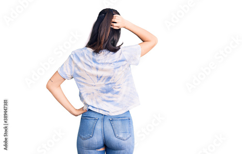 Young beautiful girl wearing casual t shirt backwards thinking about doubt with hand on head © Krakenimages.com