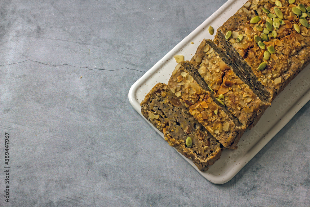 Gluten free and sugar free pumpkin bread cut into pieces. Pumpkin cake with dried fruits, poppy seeds and honey on a dark table. Copy space. Vegan Pumpkin Pastry Gluten free and sugar free pumpkin bread cut into pieces. Pumpkin cake with dried fruits, poppy seeds and honey on a dark table. Copy space. Vegan Pumpkin Pastry
