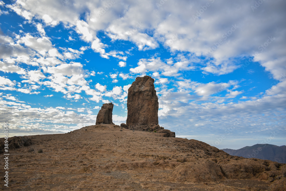 Roque nublo photographed at sunset with a slightly cloudy blue sky.