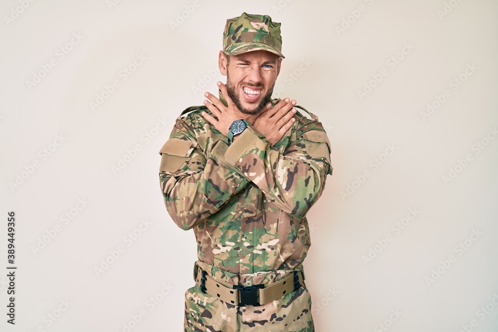 Young caucasian man wearing camouflage army uniform shouting suffocate because painful strangle. health problem. asphyxiate and suicide concept. Young caucasian man wearing camouflage army uniform shouting suffocate because painful strangle. health problem. asphyxiate and suicide concept.