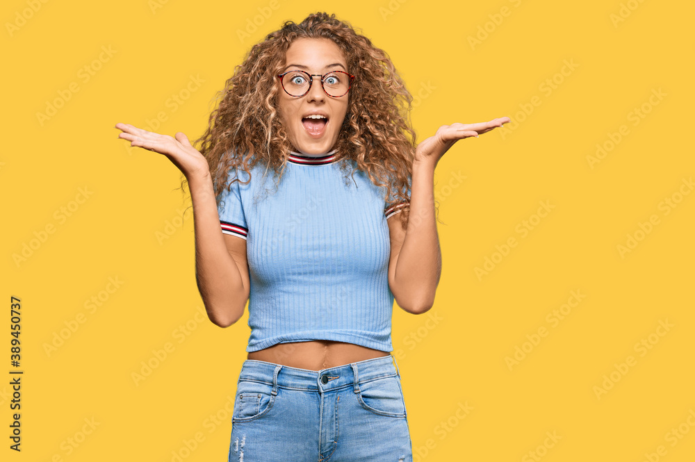 Beautiful caucasian teenager girl wearing casual clothes and glasses celebrating crazy and amazed for success with arms raised and open eyes screaming excited. winner concept Beautiful caucasian teenager girl wearing casual clothes and glasses celebrating crazy and amazed for success with arms raised and open eyes screaming excited. winner concept