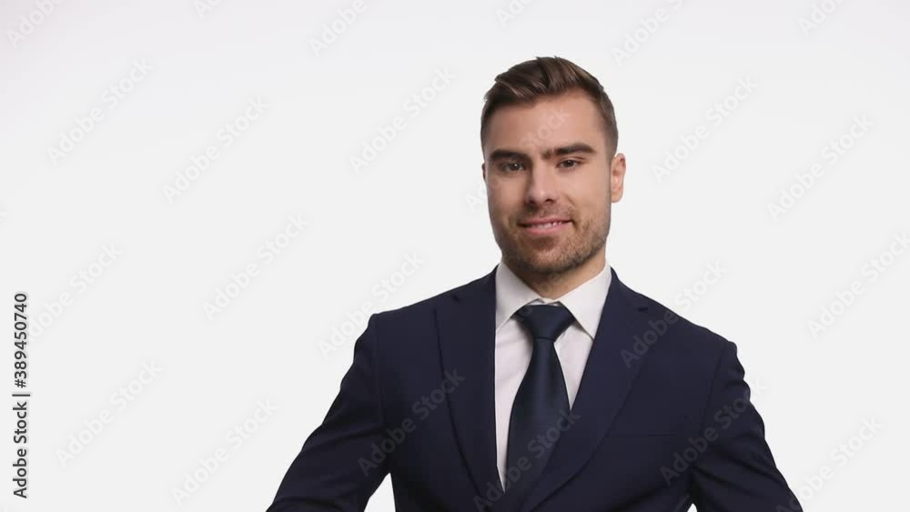 attractive man looking down, buttoning navy blue suit and smiling, crossing arms and standing isolated on white background in studio attractive man looking down, buttoning navy blue suit and smiling, crossing arms and standing isolated on white background in studio
