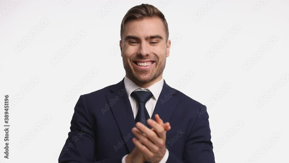 enthusiastic attractive guy wearing navy blue suit laughing, applauding and making thumbs up gesture on white background in studio enthusiastic attractive guy wearing navy blue suit laughing, applauding and making thumbs up gesture on white background in studio