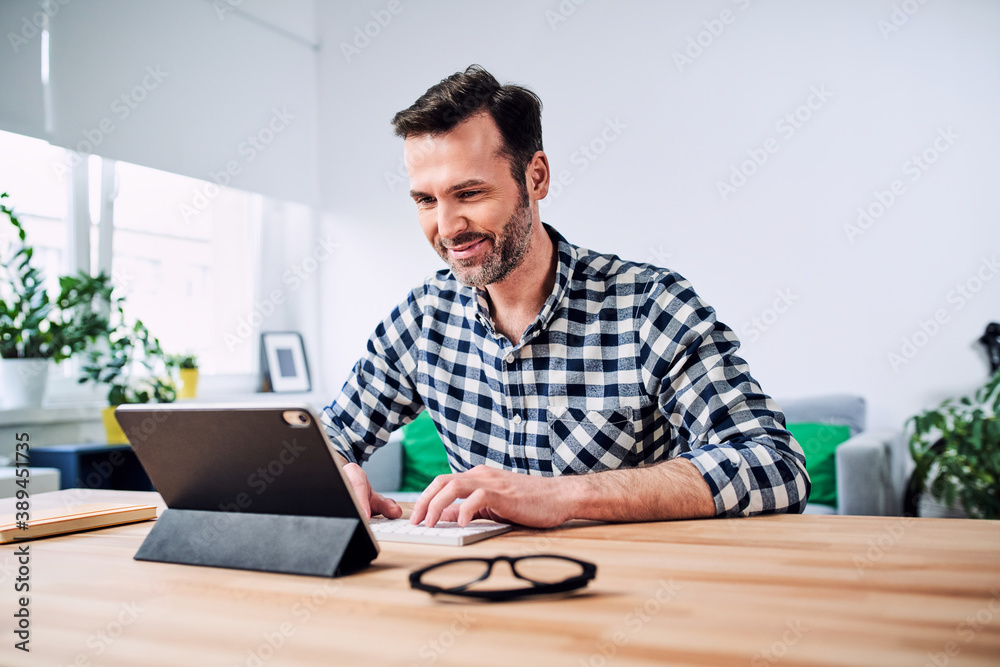 Man working from home using digital tablet Man working from home using digital tablet
