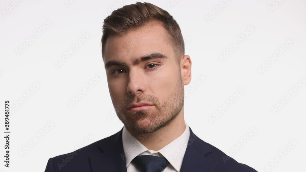 arrogant young guy in navy blue suit crossing arms, touching chin in a seductive manner, arranging tie and thinking, standing and posing isolated on white background arrogant young guy in navy blue suit crossing arms, touching chin in a seductive manner, arranging tie and thinking, standing and posing isolated on white background