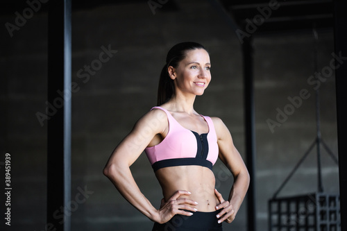 Portrait attractive smiling fit woman indoors.