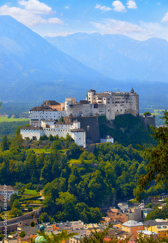 Fortress Salzburg in Austria medieval castle at cliff under the old town. Famous landmark with summer sky with clouds.