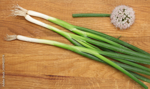 Fresh green onion on a wooden background. Top view