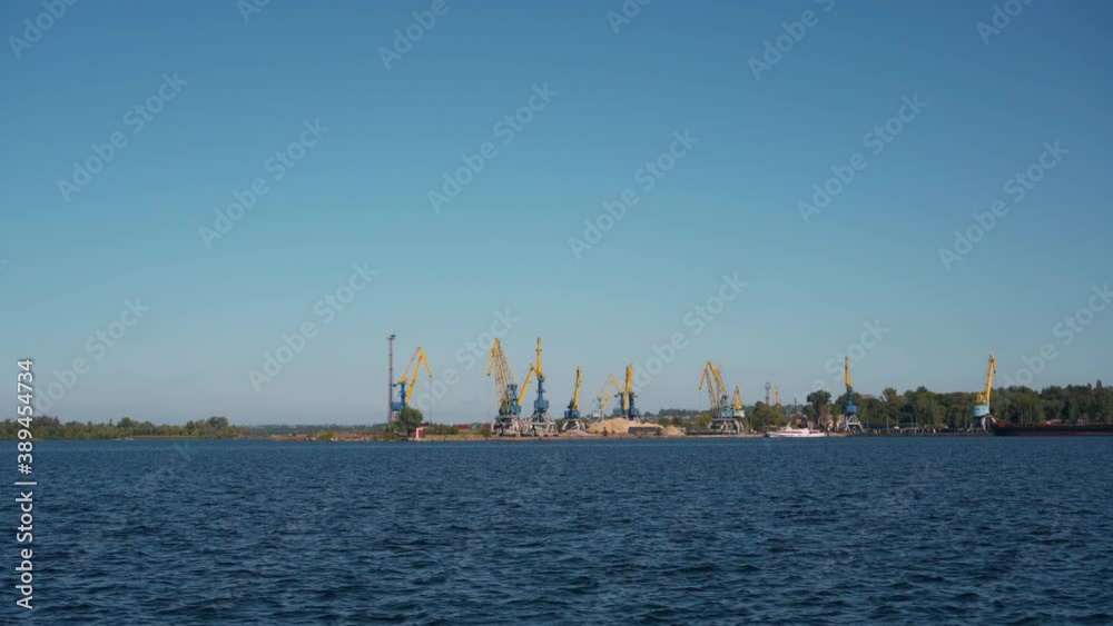 Panorama of the river port with many loading cranes. Water area on a sunny day. Panorama of the river port with many loading cranes. Water area on a sunny day.