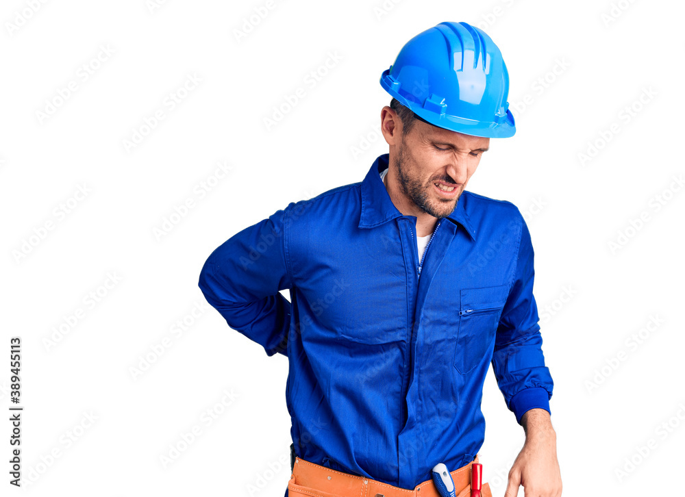 Young handsome man wearing worker uniform and hardhat suffering of neck ache injury, touching neck with hand, muscular pain