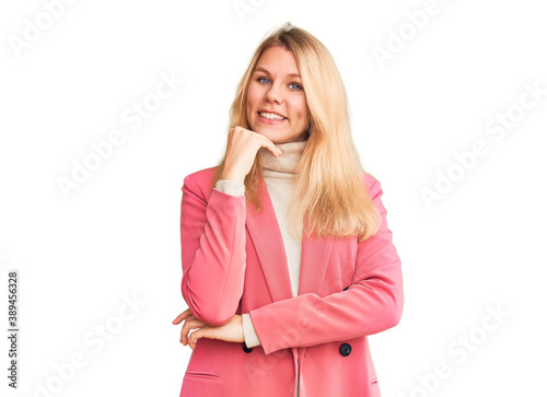 Young beautiful blonde woman wearing elegant clothes looking confident at the camera with smile with crossed arms and hand raised on chin. thinking positive.