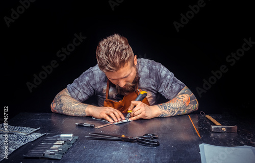 Leather Artist produces leather goods in the workshop photo