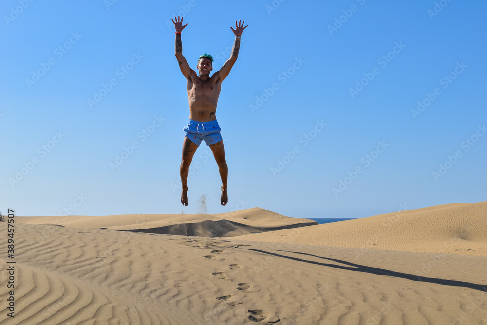 Man on vacation, running and jumping in the desert sand dunes. Man on vacation, running and jumping in the desert sand dunes.
