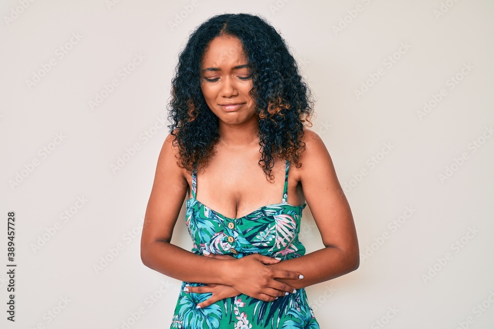 Young african american woman wearing casual clothes with hand on stomach because indigestion, painful illness feeling unwell. ache concept. Young african american woman wearing casual clothes with hand on stomach because indigestion, painful illness feeling unwell. ache concept.