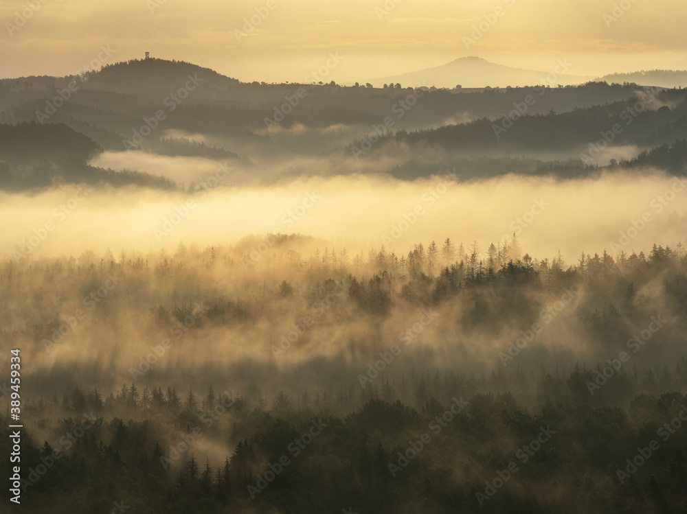 Blick in den Morgenstunden von den Affensteinen über Alten Wildenstein Richtung Lichtenhain. Die Sonne schickt ihre ersten wärmenden Strahlen durch den dichten Nebel in die Bergwelt des Nationalparkes