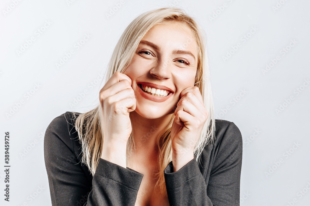 Beautiful happy young girl smiles on gray isolated background Beautiful happy young girl smiles on gray isolated background
