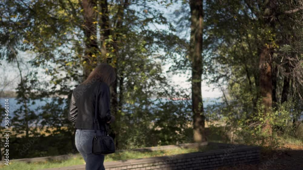 Lonely slender woman walks in a city park on an autumn day. Gait of a beautiful woman. Medium shot. Lonely slender woman walks in a city park on an autumn day. Gait of a beautiful woman. Medium shot.