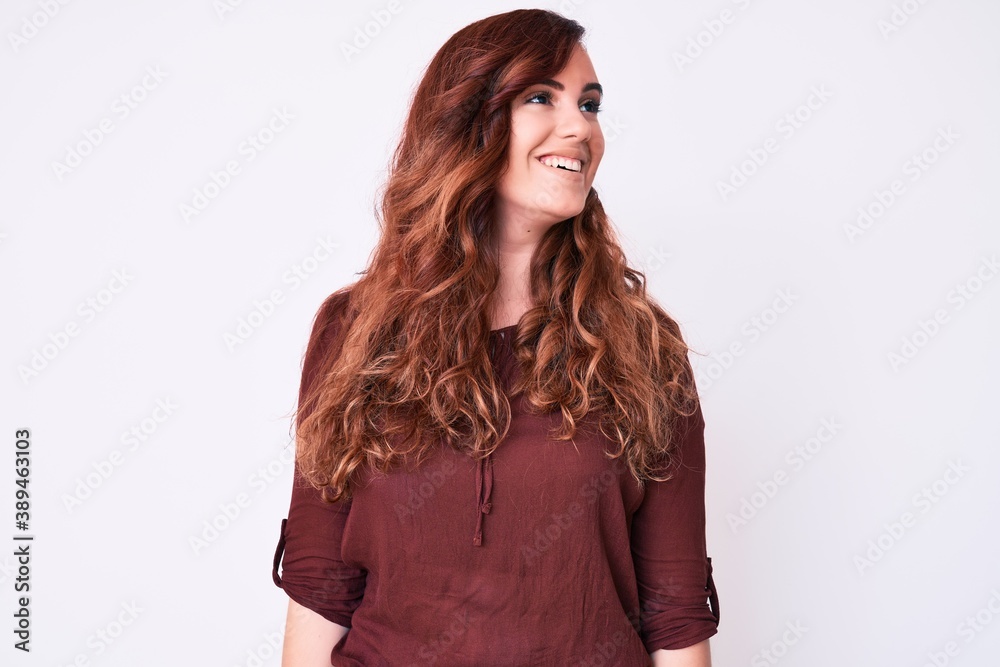 Young beautiful woman wearing casual clothes looking away to side with smile on face, natural expression. laughing confident. Young beautiful woman wearing casual clothes looking away to side with smile on face, natural expression. laughing confident.