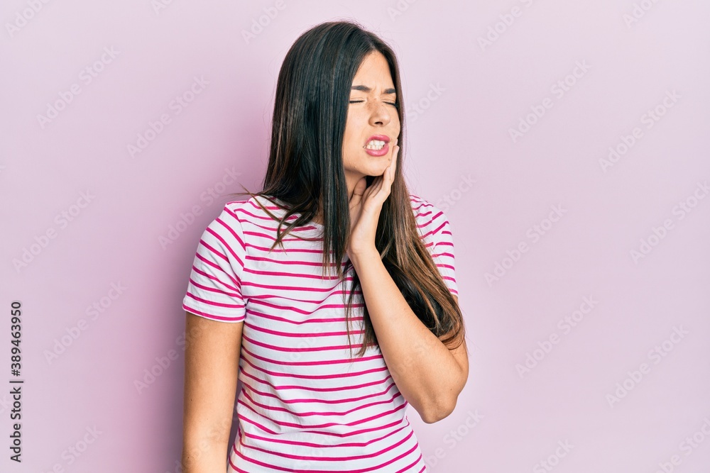 Young brunette woman wearing casual clothes over pink background touching mouth with hand with painful expression because of toothache or dental illness on teeth. dentist Young brunette woman wearing casual clothes over pink background touching mouth with hand with painful expression because of toothache or dental illness on teeth. dentist