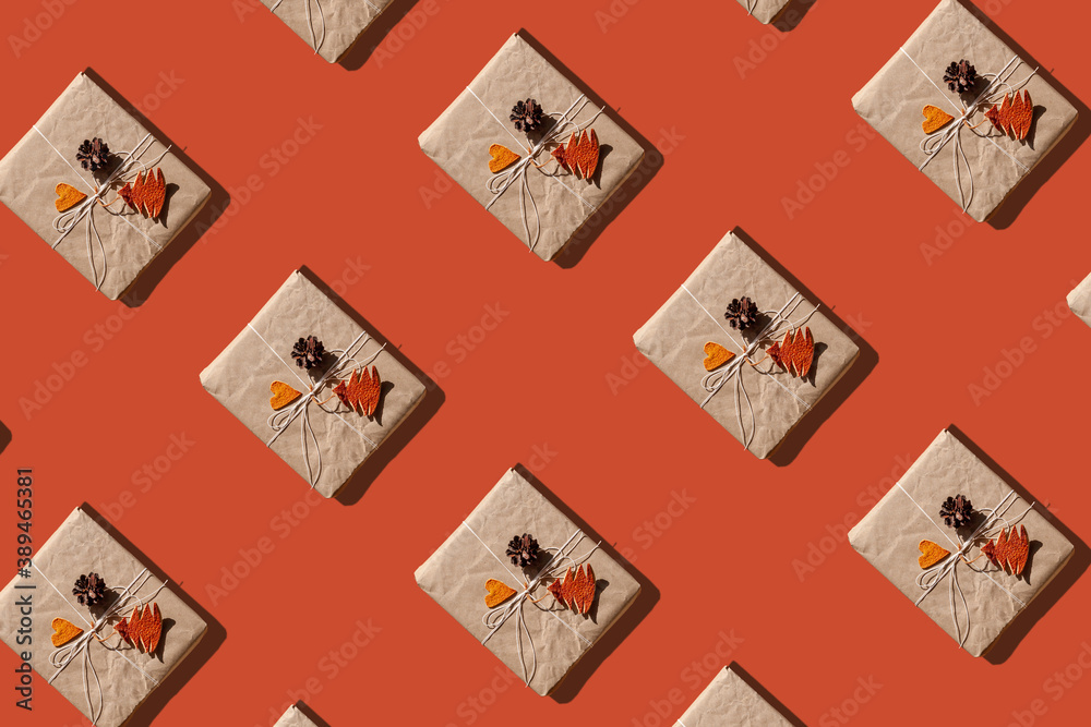 Trendy Christmas pattern made with paper gift boxes photo on pastel orange background. Minimal zero waste New Year concept. Greeting card wallpaper mockup.Winter holiday creative eco friendly backdrop