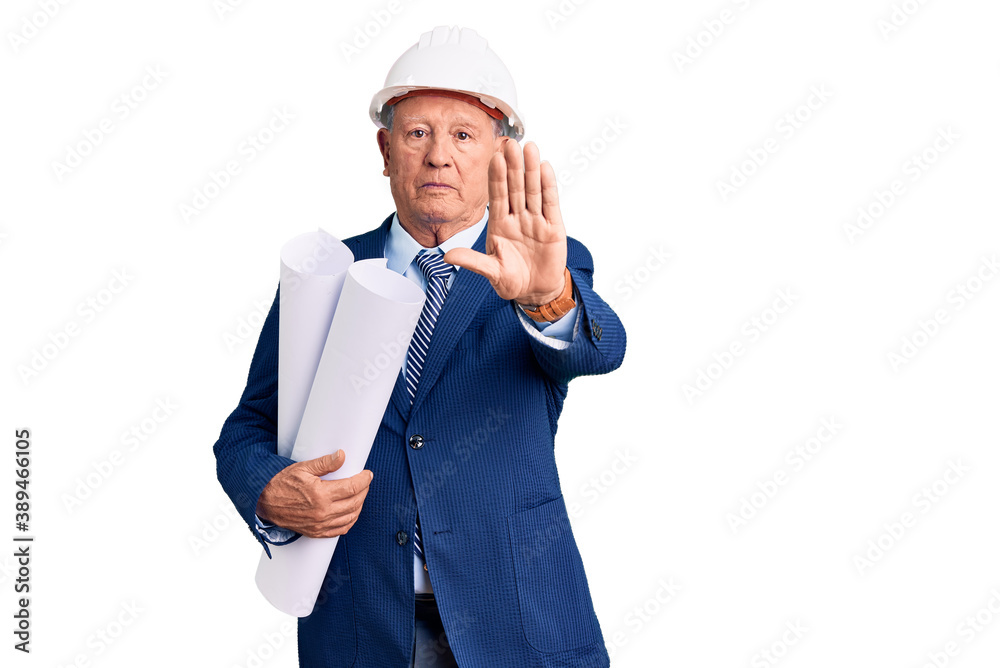 Senior handsome grey-haired man wearing architect hardhat holding blueprints with open hand doing stop sign with serious and confident expression, defense gesture Senior handsome grey-haired man wearing architect hardhat holding blueprints with open hand doing stop sign with serious and confident expression, defense gesture