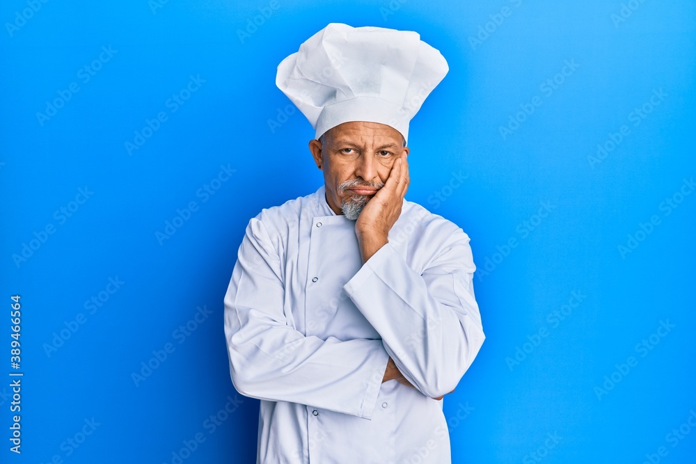 Middle age grey-haired man wearing professional cook uniform and hat thinking looking tired and bored with depression problems with crossed arms. Middle age grey-haired man wearing professional cook uniform and hat thinking looking tired and bored with depression problems with crossed arms.