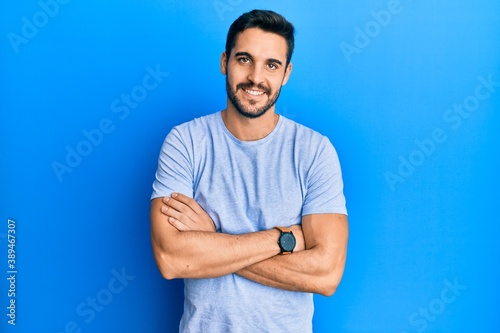 Young hispanic man wearing casual clothes happy face smiling with crossed arms looking at the camera. positive person.