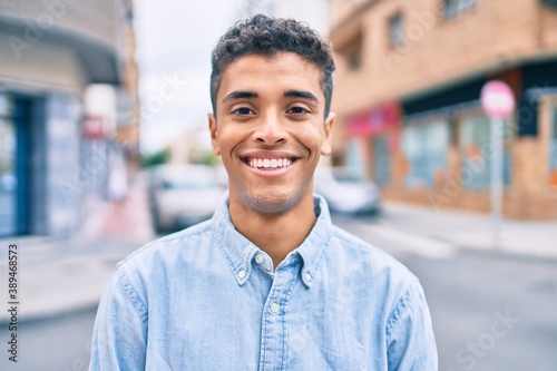 Young latin man smiling happy walking at the city.