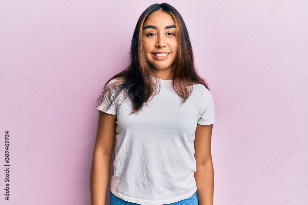 Young latin woman wearing casual white tshirt with a happy and cool smile on face. lucky person. Young latin woman wearing casual white tshirt with a happy and cool smile on face. lucky person.