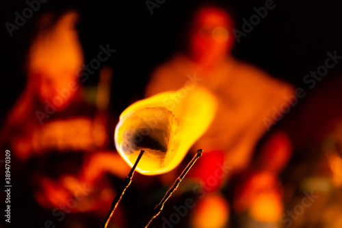 Roasting a marshmallow around a campfire to make s'mores