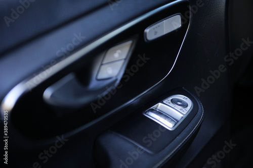 close-up of the side door buttons: window adjustment buttons, door lock. modern car interior: parts, buttons, knobs