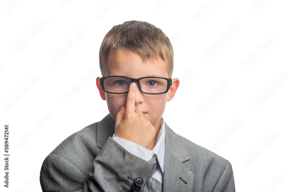 Child dressed as an adult businessman straightens glasses with his finger. Face of smart boy in glasses and adult suit isolated on white background