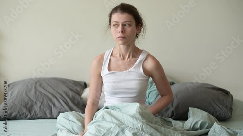 A young woman overslept, gets out of bed abruptly and runs away to get ready for work or school