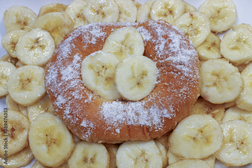 delicious cake with ripe bananas. Doughnut in powdered sugar. Sweet dessert