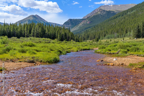 Summer Mountain Creek - Mineral-rich Geneva Creek running in a lush green valley at base of high peaks of Continental Divide, near Guanella Pass, Grant, Colorado, USA. photo
